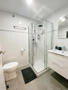 łazienka z prysznicem, toaletą i umywalką w obiekcie GMC Turistics - Great Apartment for Groups & Families w Maladze