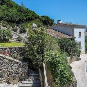 una casa con una pared de piedra y un árbol en Rio d'Azenha - Country House en Roliça