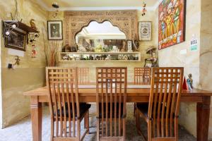 a dining room with a wooden table and chairs at OYO 401 The Frog Homestay Sanur in Sanur