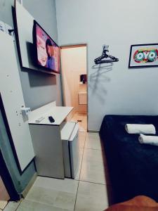 a room with a bed and a desk and a television at Ágape Hotel in Rio Verde