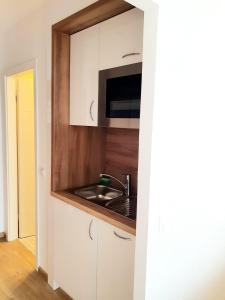 eine Küche mit einer Spüle und einer Mikrowelle in der Unterkunft Haus am See Luxury HS 948 in Hahnenklee-Bockswiese