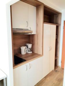 eine Küche mit weißen Schränken und einer Mikrowelle in der Unterkunft Haus am See Luxury HS 948 in Hahnenklee-Bockswiese