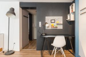ein Heimbüro mit einem Schreibtisch und einem weißen Stuhl in der Unterkunft Appartements de la Pléiade in Straßburg