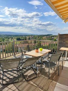 einen Holztisch und Stühle auf einer Terrasse mit Aussicht in der Unterkunft gite horizon in Neulise