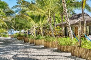 a beach with palm trees and a resort at Villa Pescadores Tulum in Tulum