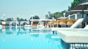 a swimming pool with lounge chairs and a swimming pool at Bravia Hotel Niamey in Niamey