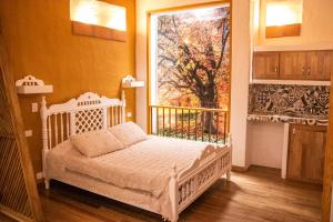 a bedroom with a bed and a painting on the wall at El Despertar Hotel in Jericó