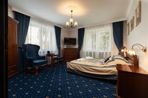a bedroom with a bed and a desk and a chair at Villa Toscania-check in 24h in Poznań
