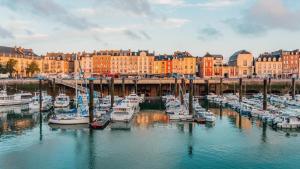 un grupo de barcos atracados en un puerto con edificios en Le Rendez-vous du Pêcheur 4 à 6 pers, en Dieppe