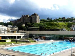 a swimming pool with a castle in the background at Le Rendez-vous du Pêcheur 4 à 6 pers in Dieppe