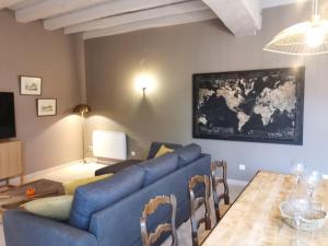 sala de estar con sofá azul y mesa en Villa Sainte-Marie - Les Bastides d'Edouard - Chablis, en Maligny