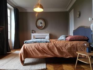 1 dormitorio con cama y espejo en Villa Sainte-Marie - Les Bastides d'Edouard - Chablis, en Maligny