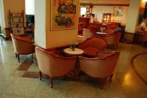 a lobby with chairs and a table in a restaurant at Charoen Thani Hotel, Khon Kaen in Khon Kaen