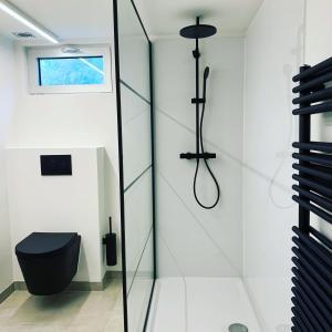 a bathroom with a black toilet and a shower at Chalet Pierco in Malmedy