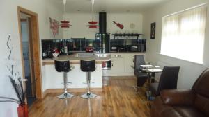 a kitchen with a counter and two bar stools at Buckton House Holiday Cottages in Bempton
