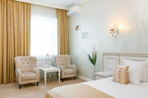 モスクワにあるHotel Invite Lyublinoのベッド1台、椅子2脚、テーブルが備わる客室です。
