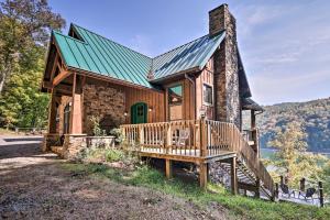 a log cabin with a porch and a green roof at Lakefront Norris Lake Cabin with Decks and Dock! in New Tazewell