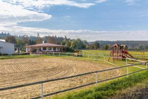 una granja con un parque infantil en un campo en Farma Slunečný Dvůr en Hermanuv Mestec