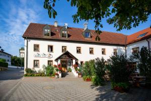ein großes weißes Gebäude mit rotem Dach in der Unterkunft Gasthaus und Hotel Göttler Josef in Rumeltshausen