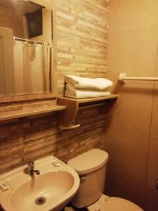 a bathroom with a white toilet and a sink at Hotel Residencial Alfa in Lima