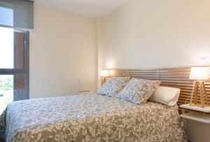 a bedroom with a bed with a wooden headboard at Apartamento Las Margas Golf Pirineo Aragones in Sabiñánigo +35 photos