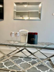 une table en verre avec deux verres et un miroir dans l'établissement Platinum Apartment przy plaży, z parkingiem, z dużym balkonem, à Sopot