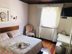 カンポス・ド・ジョルドンにあるPousada Ararinha Azulのベッドルーム1室(ベッド1台、大きな窓付)