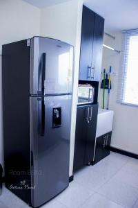 a kitchen with a stainless steel refrigerator and cabinets at Apartamento cerca al Parque del Café, Eje Cafetero in Montenegro
