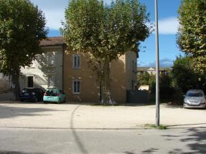 a car parked in a parking lot next to a house at Appartement tout confort 2-4 personnes Joyeuse-ARDECHE in Joyeuse