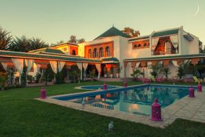 a large house with a swimming pool in the yard at Villa Des Ambassadors in Rabat