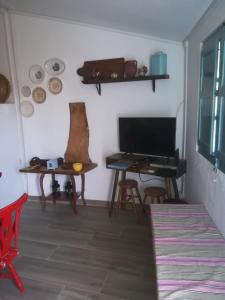 a living room with a table and a desk with a television at Monchique Typical House in Monchique