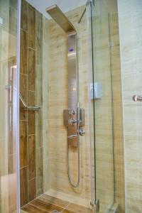 um chuveiro com uma porta de vidro na casa de banho em Hotel Tami Residence em Niš