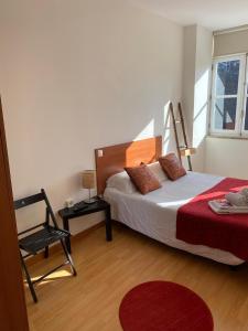 1 dormitorio con 1 cama, 1 silla y 1 ventana en Formosa Oporto Apartments Group, en Oporto