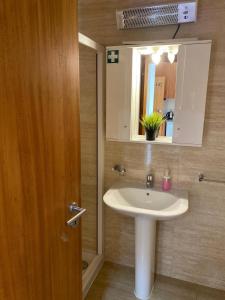 Formosa Oporto Apartments Group في بورتو: حمام مع حوض ومرآة