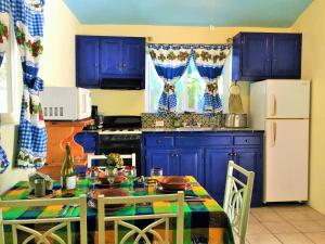 a kitchen with blue cabinets and a table with chairs at Coco Cabañas and Casitas Vacation Rentals in Loreto