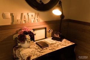 a table with a lamp and a book and a mirror at Casa Aldeia da Lapa in Sernancelhe