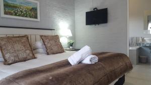 Un dormitorio con una cama con toallas. en 128 Clarens Golf Villa, en Clarens