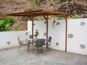 a table and chairs under a wooden canopy on a patio at Apartamento casa Bibiana 2 in Hermigua