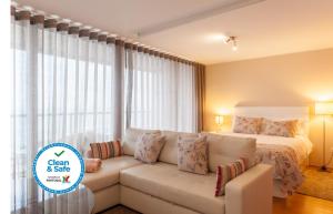 sala de estar con sofá y cama en Bartolomeu Beach Apartments, en Oporto