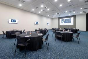 uma sala de conferências com mesas e cadeiras e um ecrã em Holiday Inn Express Hotel & Suites Hermosillo, an IHG Hotel em Hermosillo