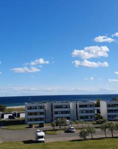 a view of a building with the ocean in the background at Südstrandflair in Fehmarn +5 photos