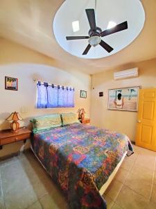 Coco Cabañas and Casitas Vacation Rentals في لوريتو: غرفة نوم بسرير ومروحة سقف