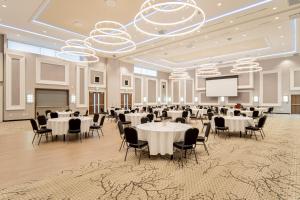 TownePlace Suites by Marriott Brantford and Conference Centre في برانتفورد: قاعة احتفالات بطاولات وكراسي وشاشة