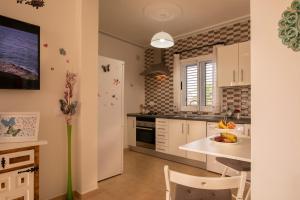 a kitchen with white cabinets and a table with a bowl of fruit at Casita Hari, donde tu y tu tiempo se detienen. in Tuineje