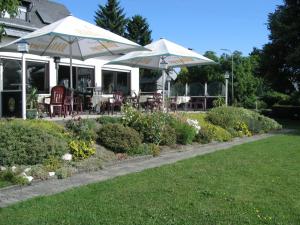 een patio met tafels, stoelen en parasols bij Gasthof Zuck in Schauren