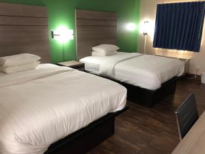 Postel nebo postele na pokoji v ubytování Travelers Inn and Suites Wharton
