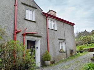 a brick house with red pipes on the side of it at Low House Farm North, Troutbeck, Windermere in Windermere