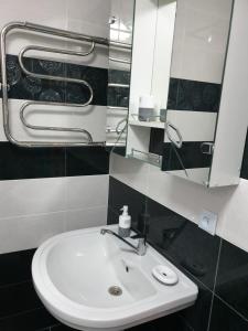 y baño con lavabo blanco y espejo. en ARTAPARTMENTS-center, en Cherníhiv