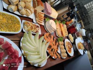 una mesa con diferentes tipos de comida en platos en Hotel Pousada Calliandra en Bonito