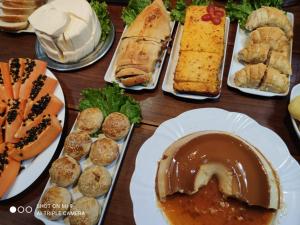 een tafel vol verschillende soorten broodjes en gebak bij Hotel Pousada Calliandra in Bonito